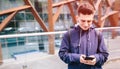 Handsome man using cell phone outdoor city street, Young attractive student casual blue shirt talking Royalty Free Stock Photo