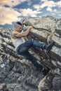 Handsome Man Climbing a Rock at the River Royalty Free Stock Photo