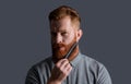 handsome man combing beard with haircomb. combing and styling. bearded man combing beard