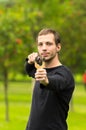 Handsome man concentrated aiming a slingshot at