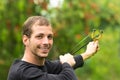 Handsome man concentrated aiming a slingshot at Royalty Free Stock Photo
