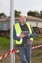 handsome man construction worker is smiling lookking tablet pad Royalty Free Stock Photo