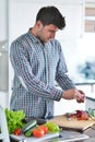Handsome man cooking at home preparing salad in kitchen. Royalty Free Stock Photo