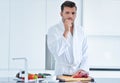 Handsome man cooking at home preparing salad in kitchen. Royalty Free Stock Photo