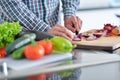 Handsome man cooking at home preparing salad in kitchen. Royalty Free Stock Photo