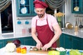 Guy holds cut zucchini in hands before steaming. A Handsome man cooking at home preparing vegan salad in kitchen. Royalty Free Stock Photo