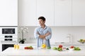 Handsome man cooking at home preparing salad in kitchen Royalty Free Stock Photo