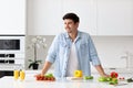 Handsome man cooking at home preparing salad in kitchen Royalty Free Stock Photo