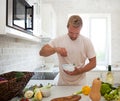 Handsome man cooking at home preparing salad in kitchen Royalty Free Stock Photo