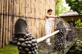 Handsome man in costume practice qigong exercises outdoors in summer terrace near the pool. Healing and spiritual Wellness, Bali,