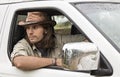 Handsome man in cowboy hat in car 4x4. Safari style. Royalty Free Stock Photo