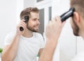 Handsome man cutting his own hair with a clipper Royalty Free Stock Photo