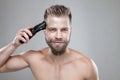 Handsome man cutting his own hair with a clipper Royalty Free Stock Photo