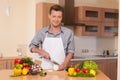 Handsome man cutting onion on chopping board. Royalty Free Stock Photo