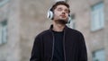 Handsome man dancing outdoors. Inspired guy enjoying music outside Royalty Free Stock Photo