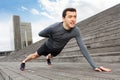 Handsome man doing push-ups on one hand outdoors