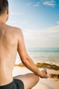 Handsome man doing yoga at cliff with blue sea background Royalty Free Stock Photo