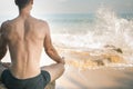 Handsome man doing yoga at cliff with blue sea background Royalty Free Stock Photo