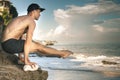 Handsome man doing yoga at cliff with blue sea background Royalty Free Stock Photo