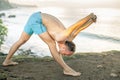 Handsome man doing yoga at cliff with blue sea background Royalty Free Stock Photo