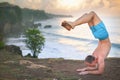 Handsome man doing yoga at cliff with blue sea background Royalty Free Stock Photo