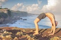 Handsome man doing yoga at cliff with blue sea background Royalty Free Stock Photo