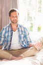 Handsome man doing yoga on his bed Royalty Free Stock Photo