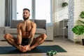 Handsome man doing yoga, stretching, resting after home workout, New Year& x27;s resolutions, exercising as healthy Royalty Free Stock Photo