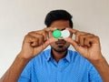 Handsome man dressed in blue shirt holding contact lens box Royalty Free Stock Photo