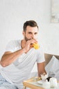 Man drinking orange juice near food tray during breakfast at home Royalty Free Stock Photo