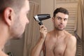 Handsome man drying his hair in the bathroom Royalty Free Stock Photo