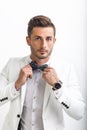 Handsome man in elegant suit adjusting his bow tie Royalty Free Stock Photo