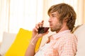 Handsome man enjoying a glass of wine on the couch Royalty Free Stock Photo