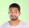 Handsome man, face and awkward look with expression in disgust or dislike on a green studio background. Confused or Royalty Free Stock Photo