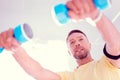 Handsome man with facial wrinkles doing morning exercise with hand weights