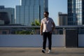 Handsome man in fashinable outfit walking on city street. Successful male model in big city living the urban lifestyle Royalty Free Stock Photo