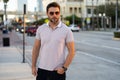 Handsome man in fashinable outfit walking on city street. Successful male model in big city living the urban lifestyle Royalty Free Stock Photo