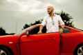 Handsome man gets out red sport car