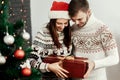 Handsome man giving christmas present to his beautiful woman in Royalty Free Stock Photo