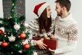 Handsome man giving christmas present to his beautiful woman in Royalty Free Stock Photo