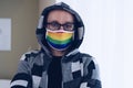 A man with glasses and an LGBT protective mask in the colors of the rainbow. Symbol of harmony, unity.