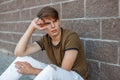 Handsome man with hair sitting near a brick wall Royalty Free Stock Photo