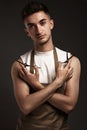 Handsome man hairdresser in a working uniform with scissors in his hands. Royalty Free Stock Photo