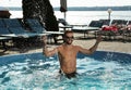 Handsome man having fun in outdoor swimming pool on day Royalty Free Stock Photo