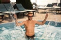 Handsome man having fun in outdoor swimming pool on sunny summer day Royalty Free Stock Photo