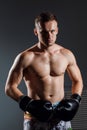 Handsome man or healthy boxer or Thai boxer with six pack wearing boxing gloves