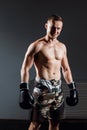 Handsome man or healthy boxer or Thai boxer with six pack wearing boxing gloves