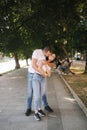 Handsome man with his gorgeous girlfriend. Happy couple walking along the embabkment. Green background