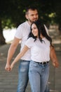 Handsome man with his gorgeous girlfriend. Happy couple walking along the embabkment. Green background