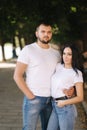 Handsome man with his gorgeous girlfriend. Happy couple walking along the embabkment. Green background